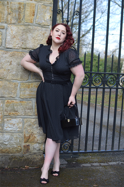 Plus size pinup Miss Amy May models the black Frilly Sundae dress gifted by Hell Bunny for a fit and size review