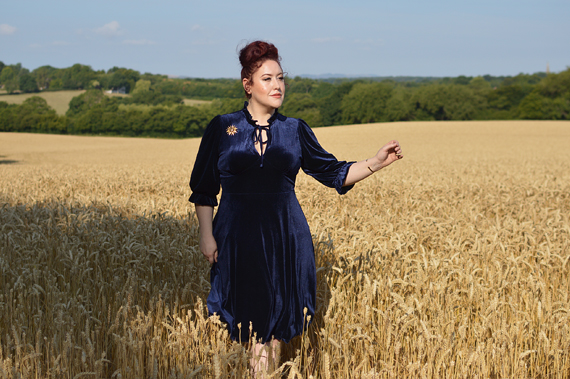 Plus size pinup Miss Amy May models the Orion navy velvet dress by Hell Bunny for a fit and size review
