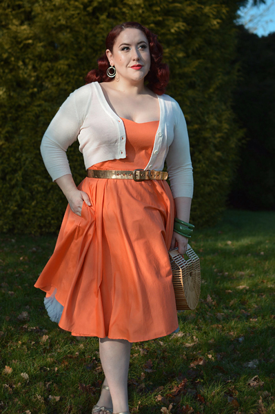 Plus size pinup Miss Amy May models the orange Heidi dress by Hell Bunny for a fit and size review